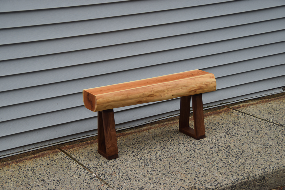 live edge yew bench with walnut legs viiewed above at an angle